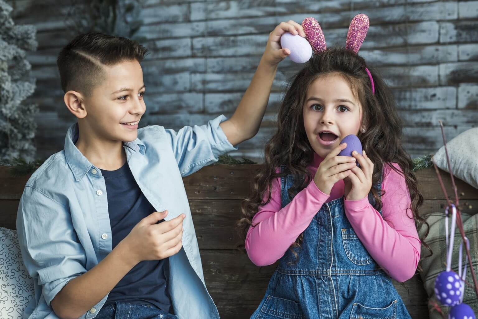 a boy and a girl holding an easter egg