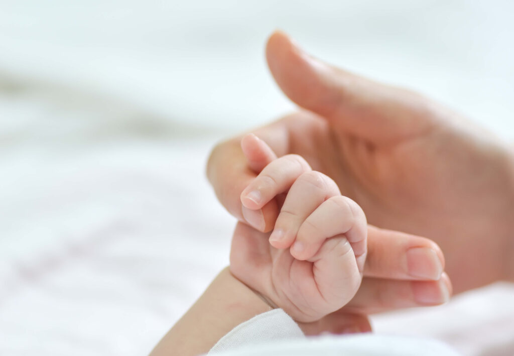 mommy hand holding newborn hand