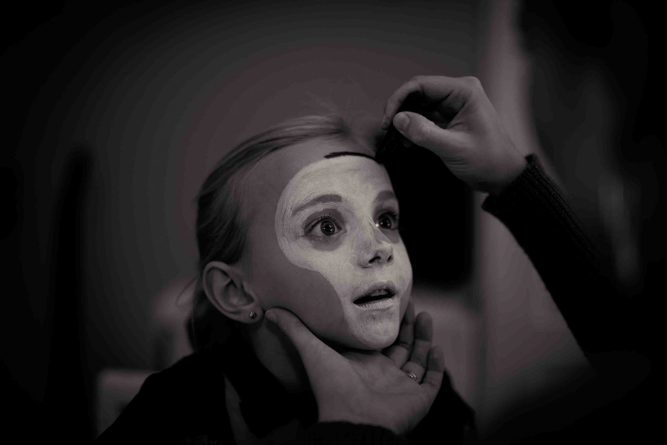 little girl getting a skeleton Halloween face paint