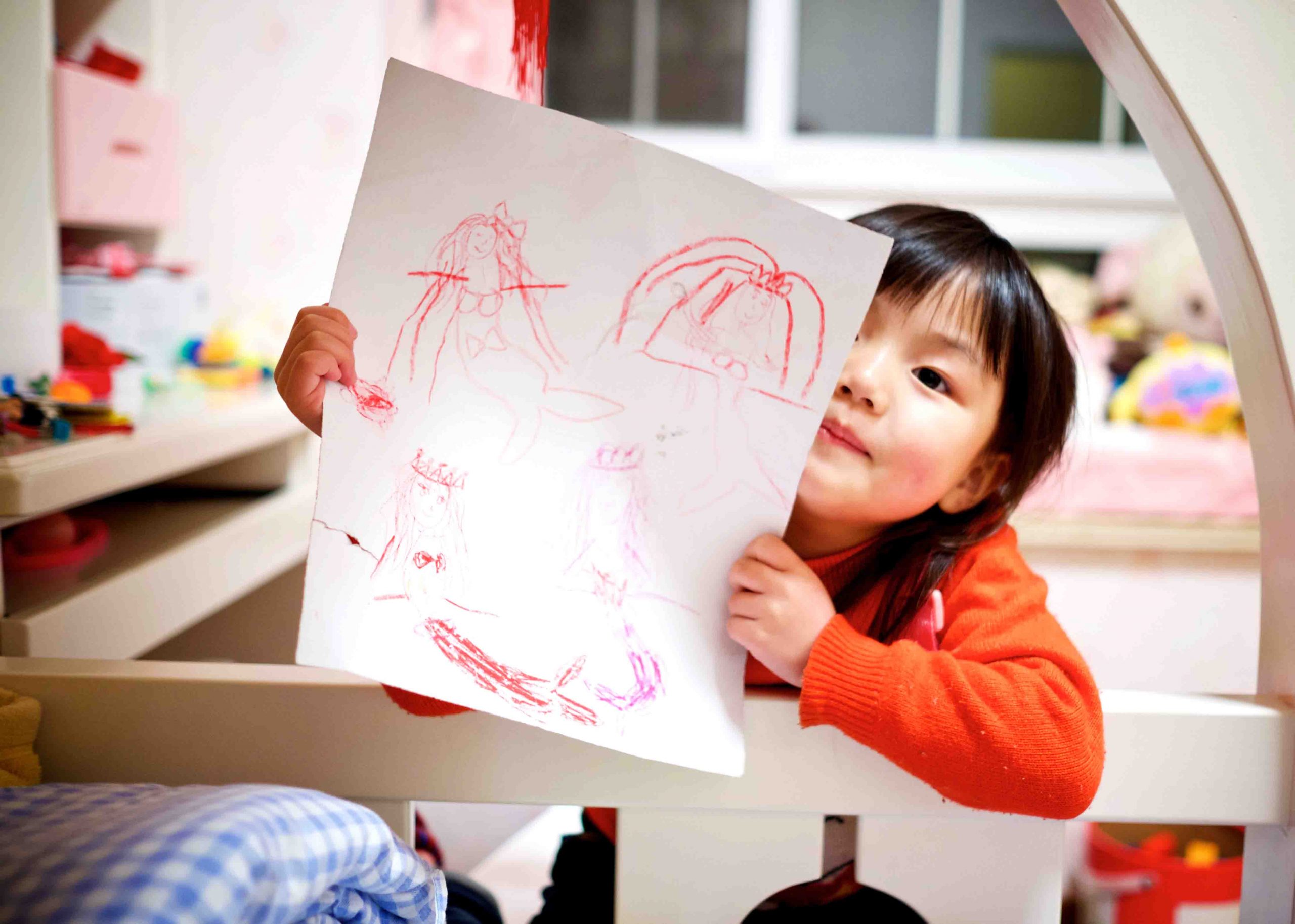 little girl showing her drawing
