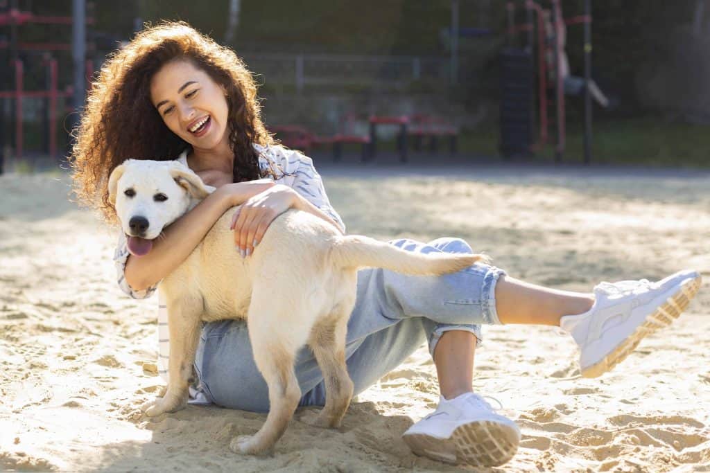 woman hugging her dog in the beach