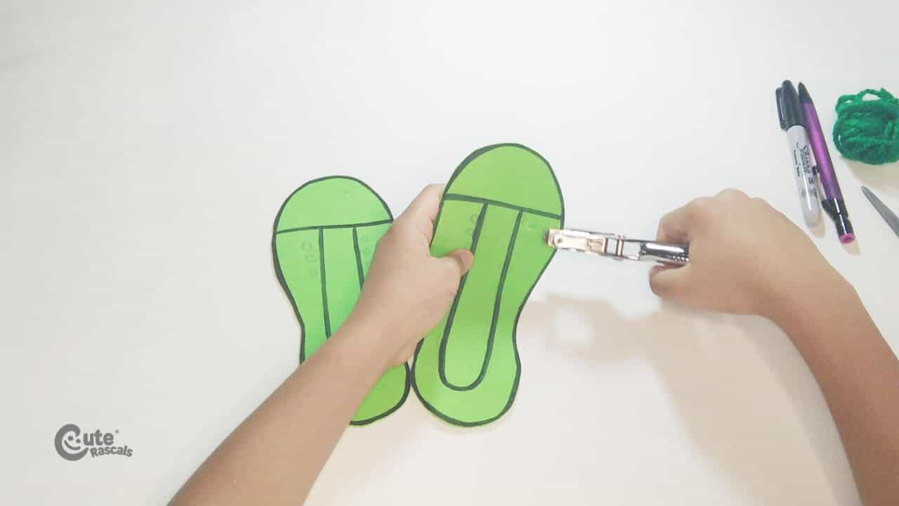 Punch holes in the Grinch's shoes. Christmas crafts for kids