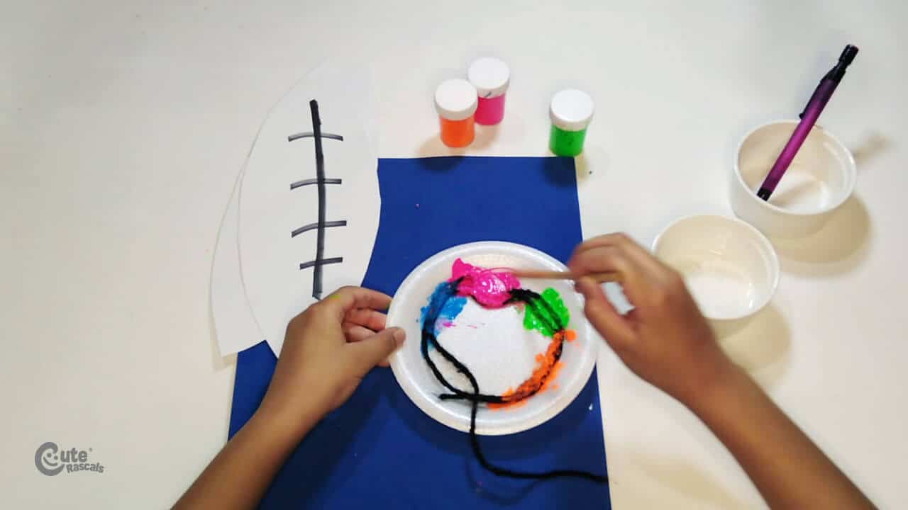 Put the paint on the plastic dish and put the yarn on top. football arts and crafts for kids