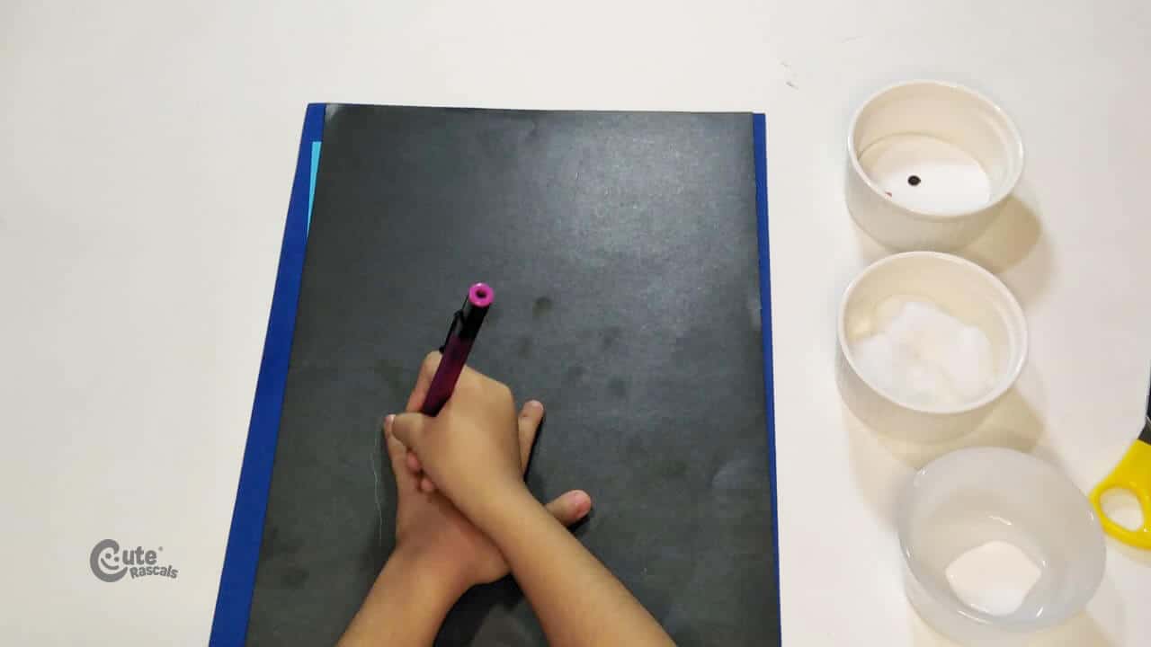 Draw your hand on the black paper